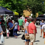 visitors browsing goods at the farmers market tents