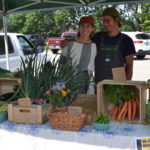 Jane and John-Paul with produce on table at farmers market